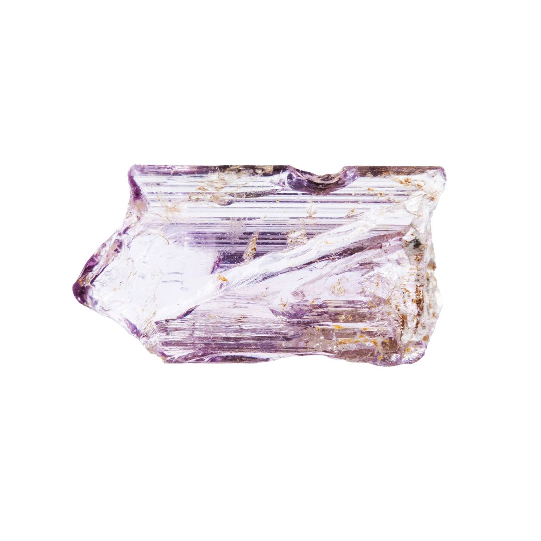 Scapolite, a shiny purple crystal looking mineral on a white background.