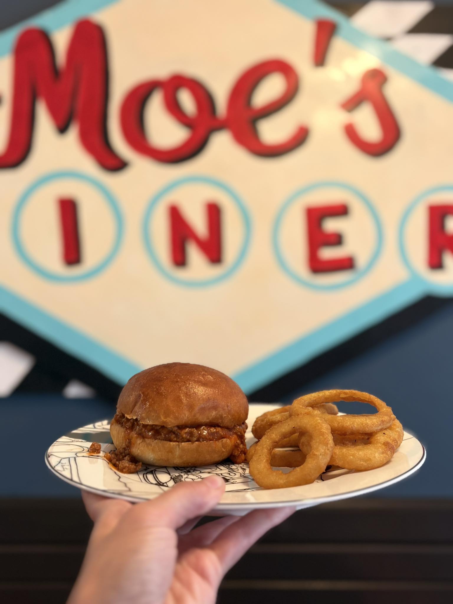 Photo of onion rings and sandwich on a plate