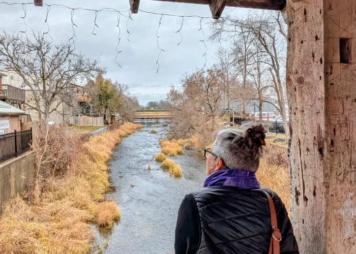 Woman leaning over railing of covered bridge at the river in Stirling